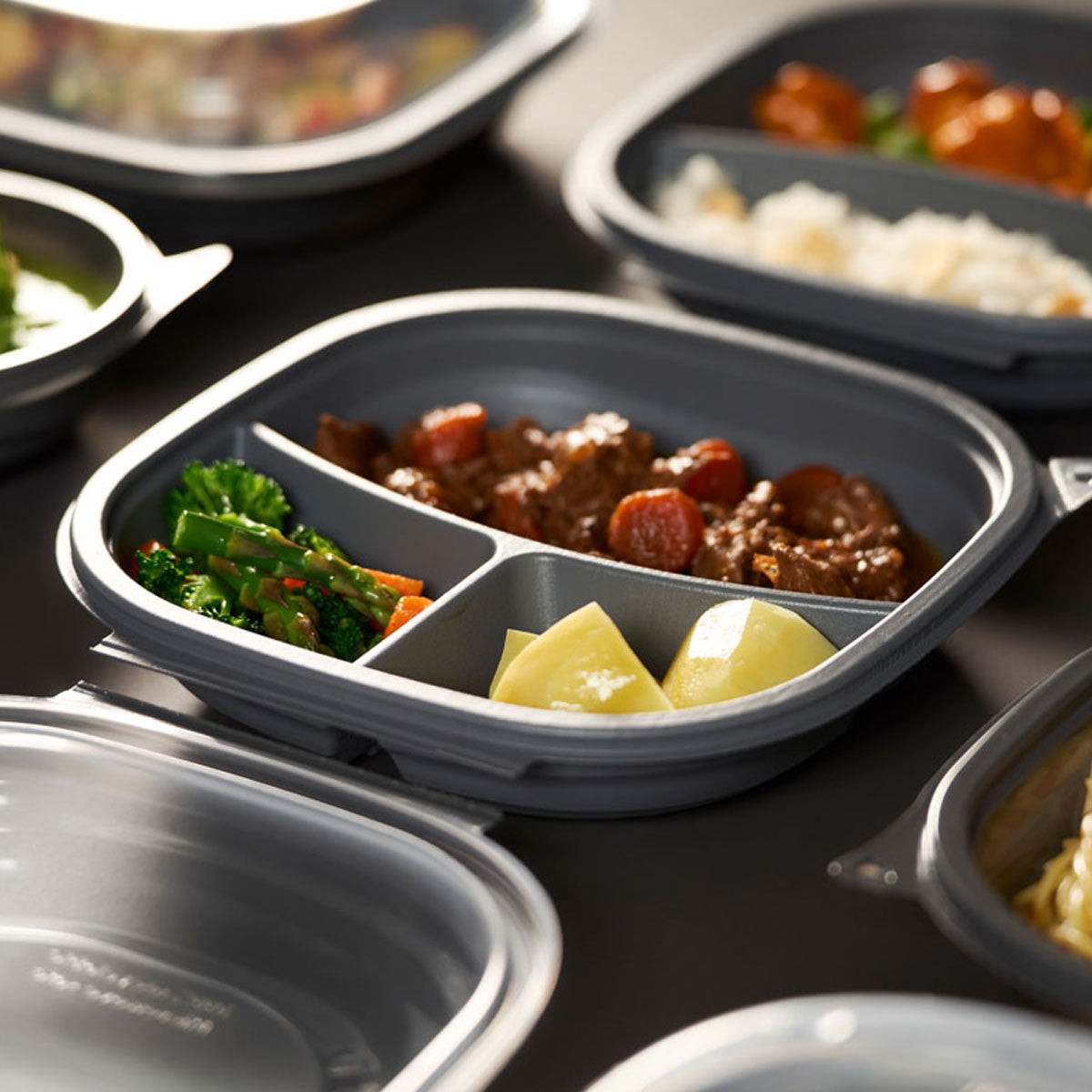 Takeaway boks i grå plast med 3 rum og gennemsigtigt låg fra Vista-serien, egnet til varme og kolde retter samt sikker transport