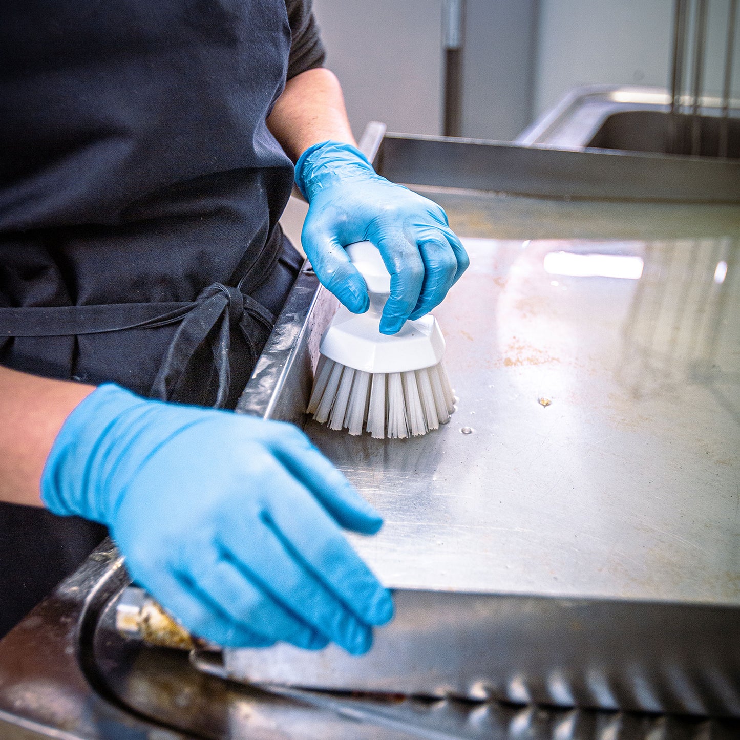 Rund skurebørste Ø110 mm i hvid med stive børstehår og ergonomisk håndtag – velegnet til rengøring af transportbånd og beholdere.