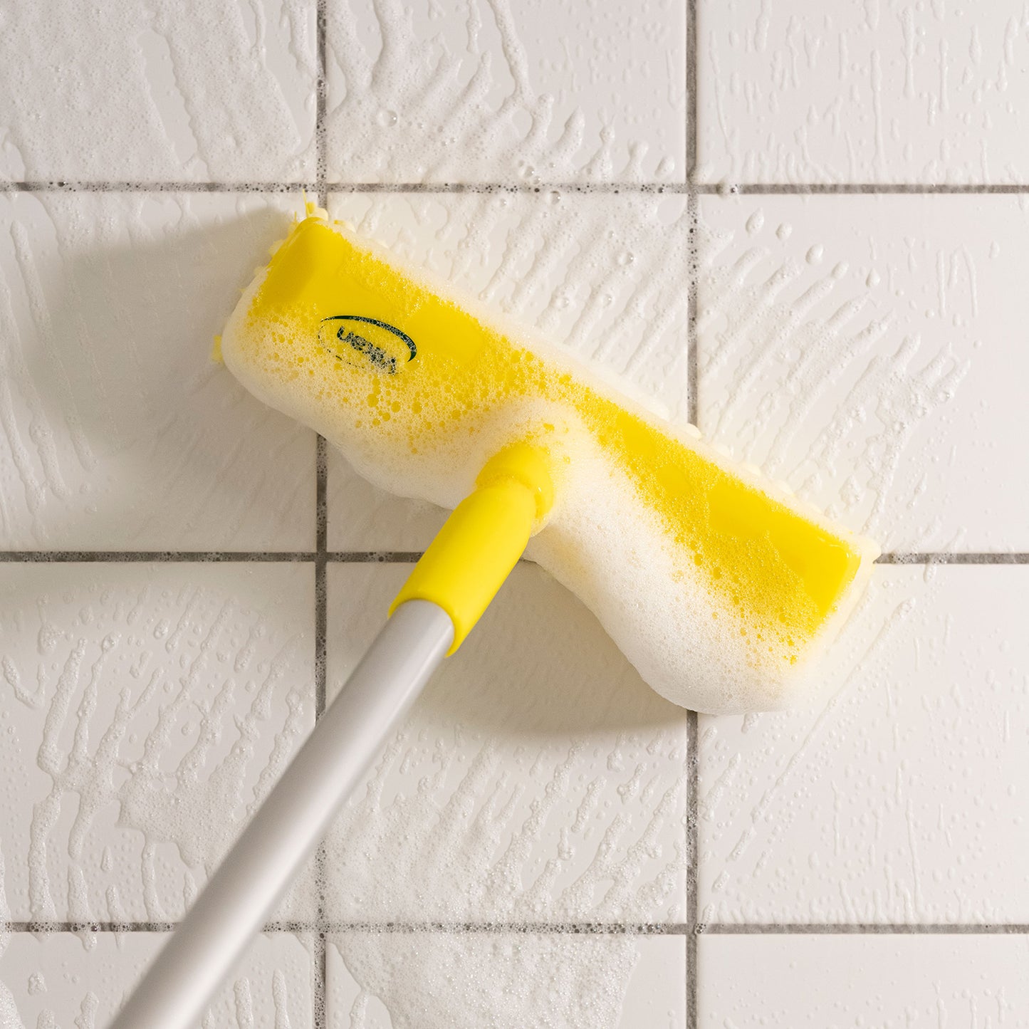 En meget stiv gulvskrubbe med vandgennemløb som sikrer en effektiv vandfordeling. Her bruges den på klinker med sæbe.