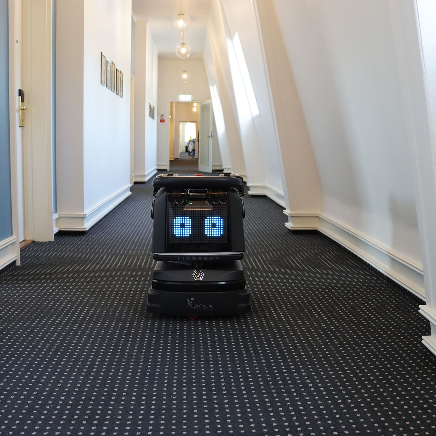 LIONSBOT R3 robotstøvsuger med ladestation, sort karros og blå lys foran